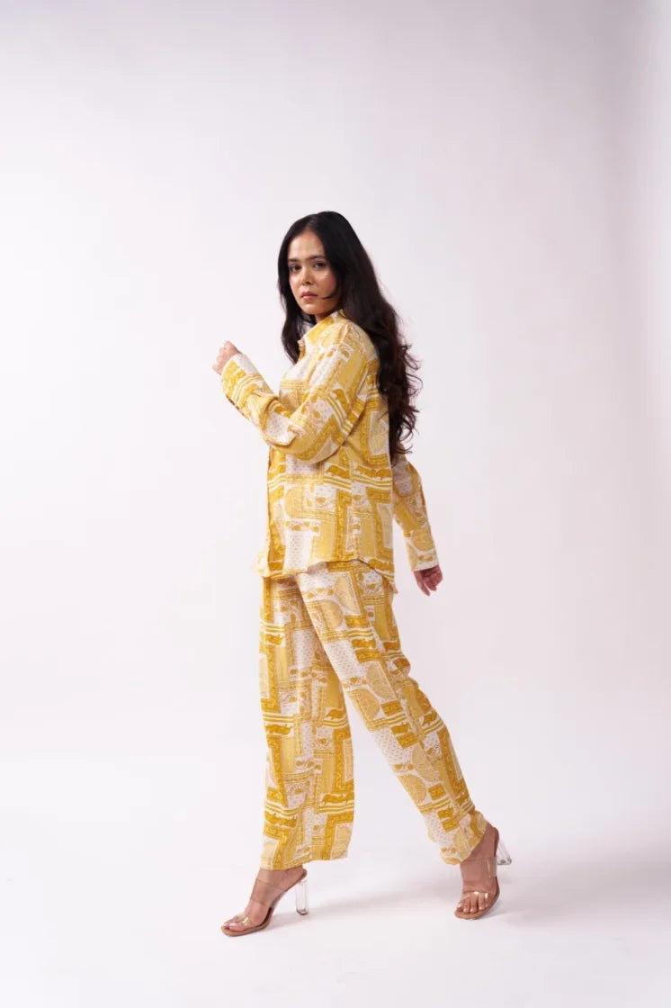 Woman wearing a yellow patterned outfit on a white background