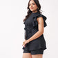 Woman wearing a black ruffled top and shorts on a white background