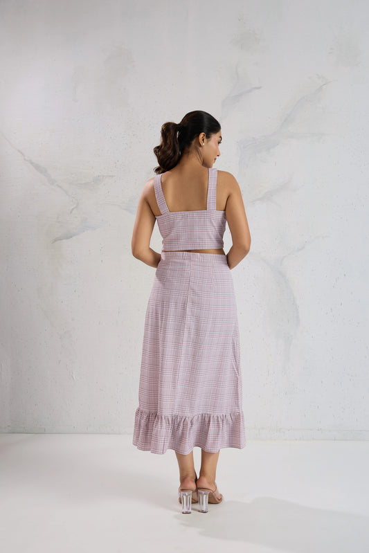 Woman wearing a pink and white checkered dress against a white background