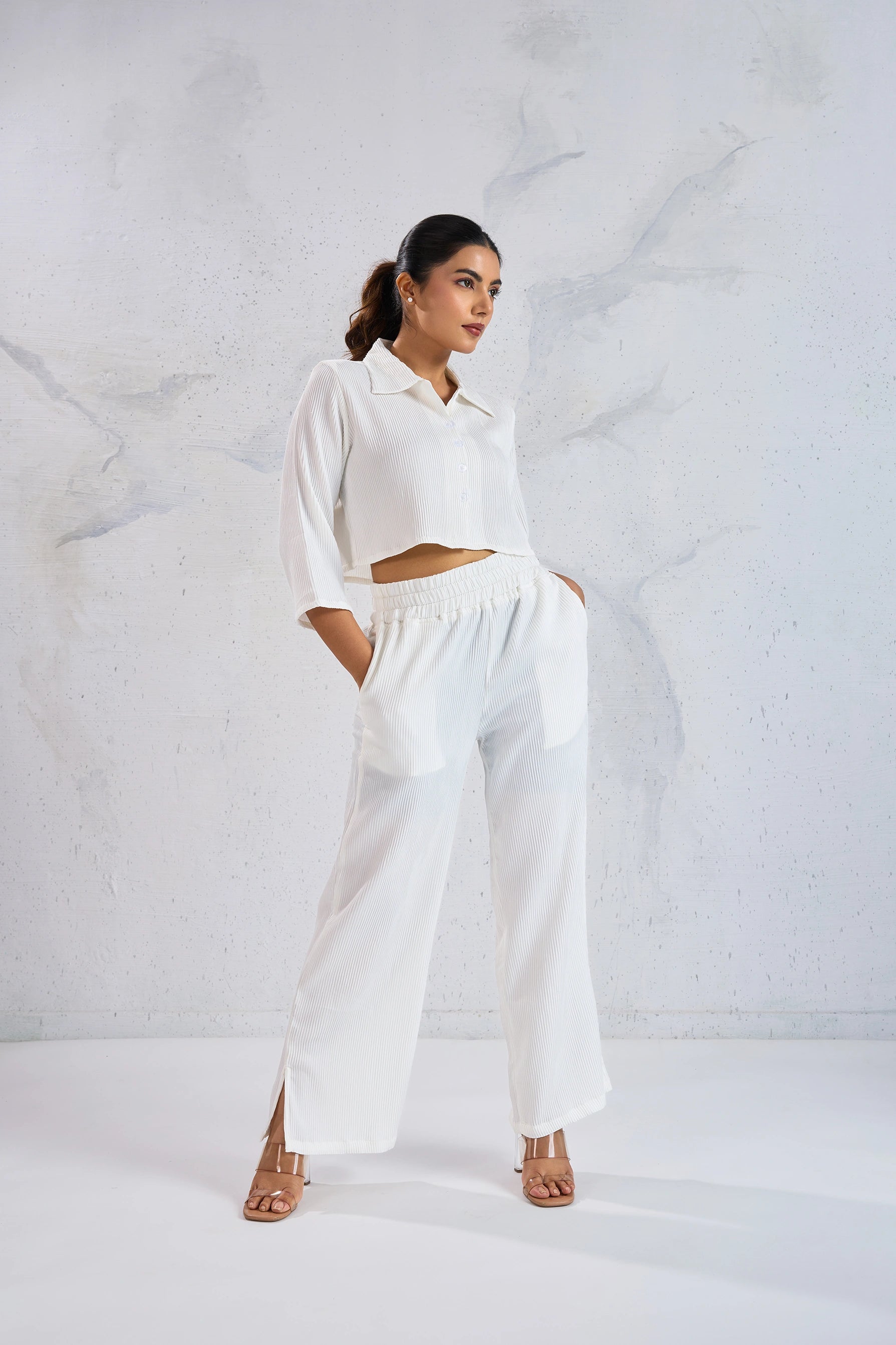 Woman wearing a white outfit against a textured white background