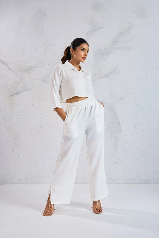 Woman wearing a white outfit against a textured white background