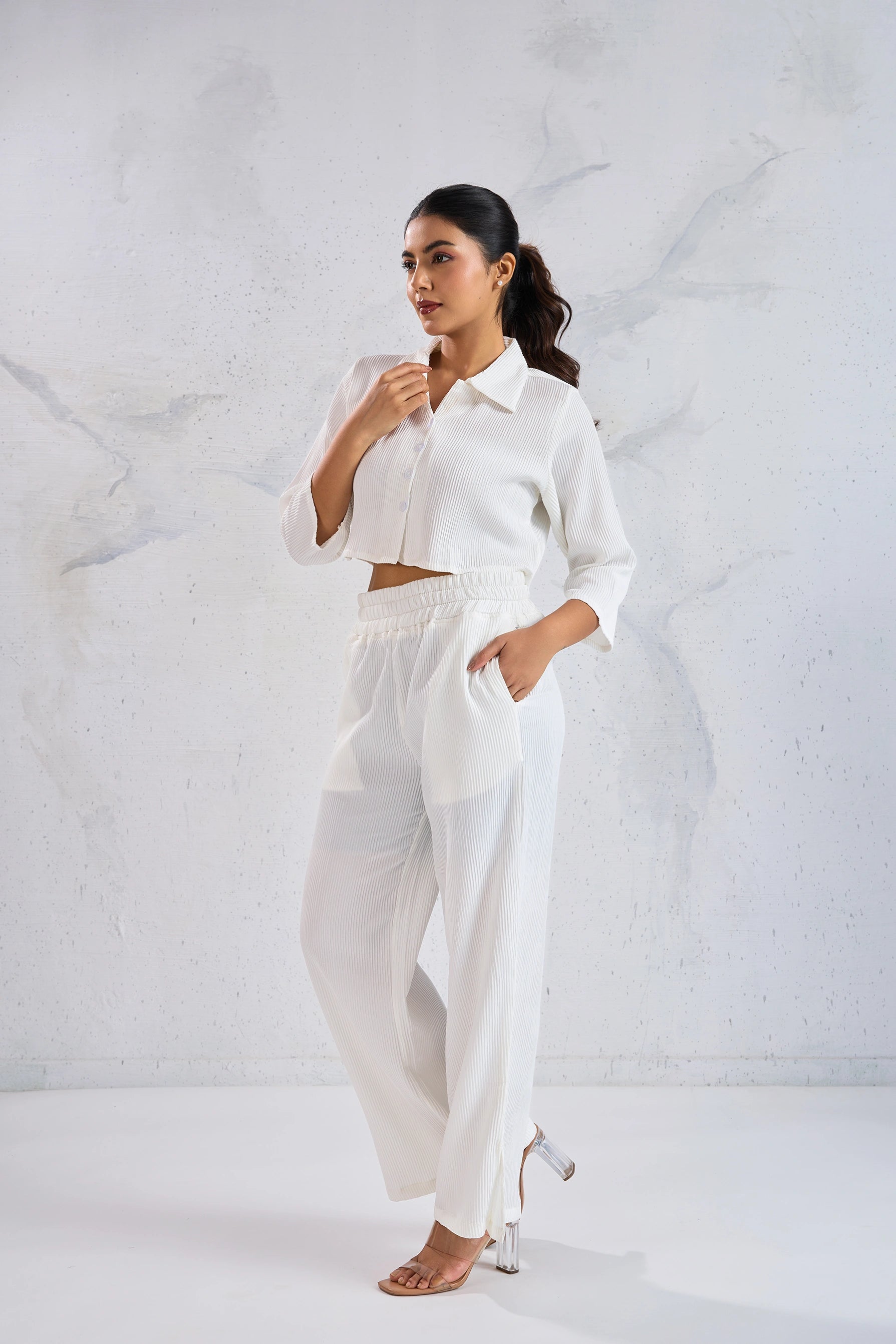 Woman wearing a white outfit against a light gray background