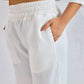 White ribbed pants worn by a person on a plain background