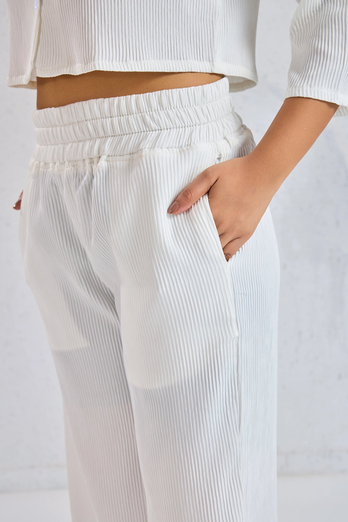 White ribbed pants worn by a person on a plain background