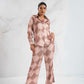Woman wearing a pink patterned outfit on a white background