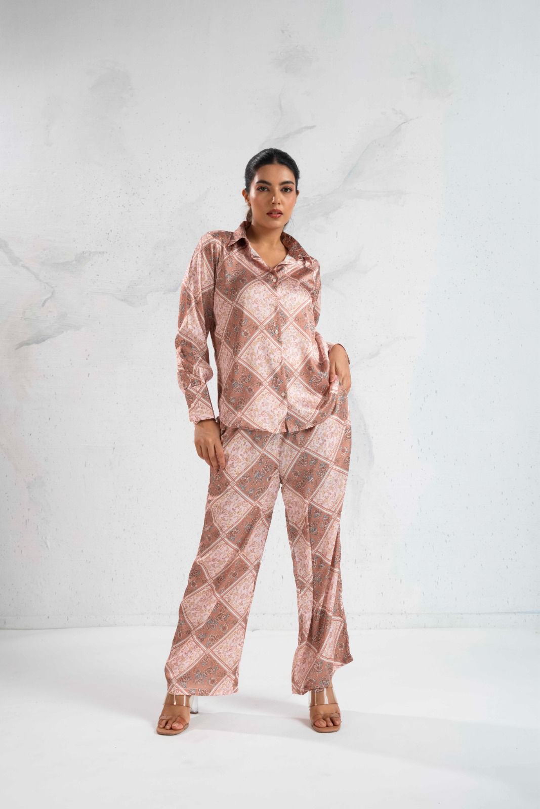 Woman wearing a pink patterned outfit on a white background