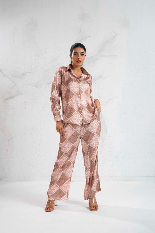 Woman wearing a pink patterned outfit on a white background