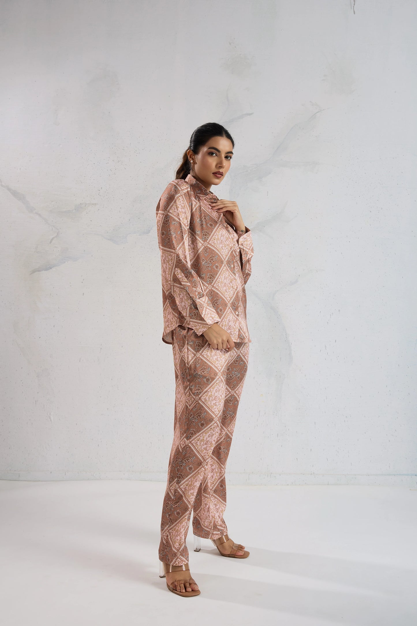 Woman wearing a patterned outfit against a white background