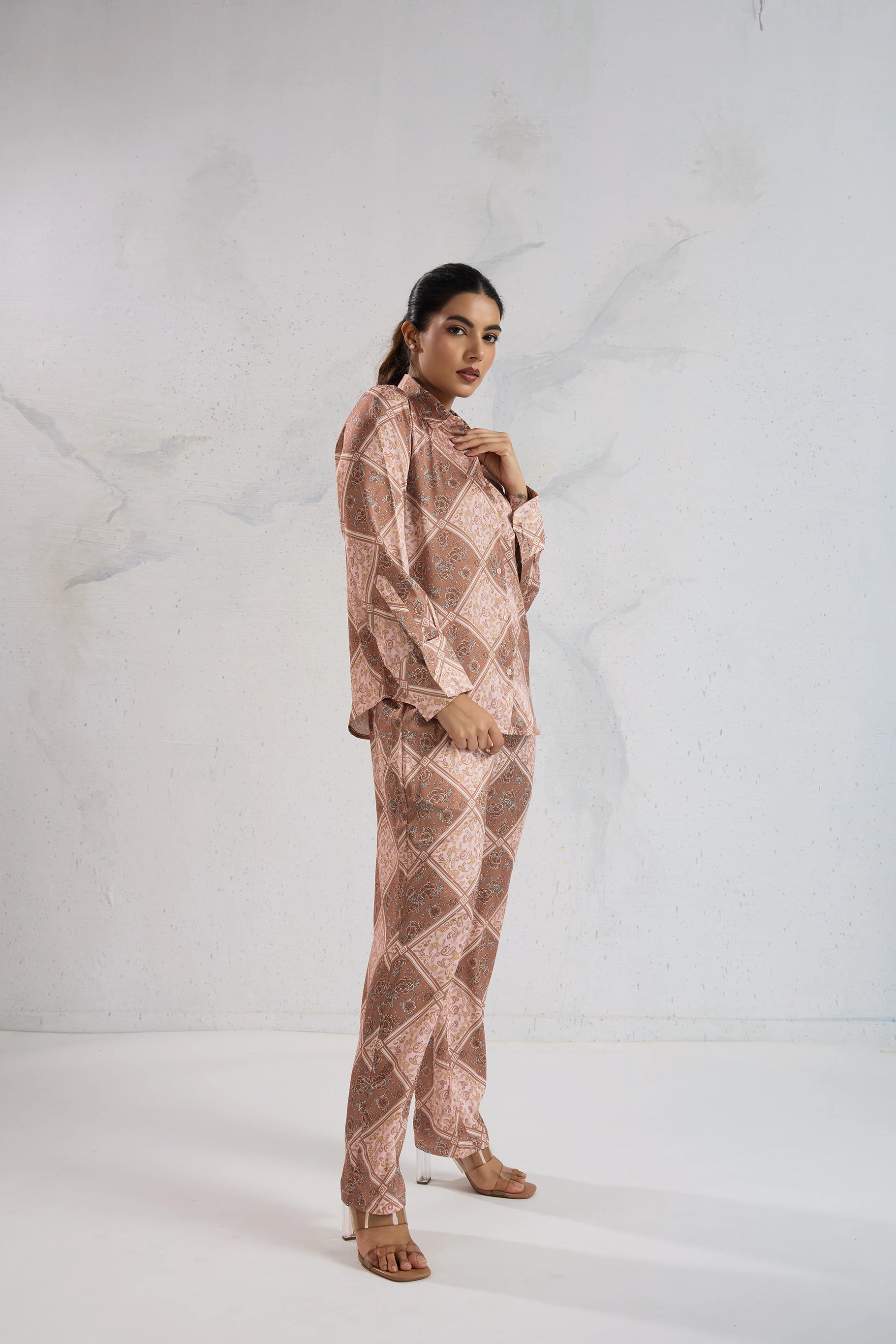 Woman wearing a patterned outfit against a white background
