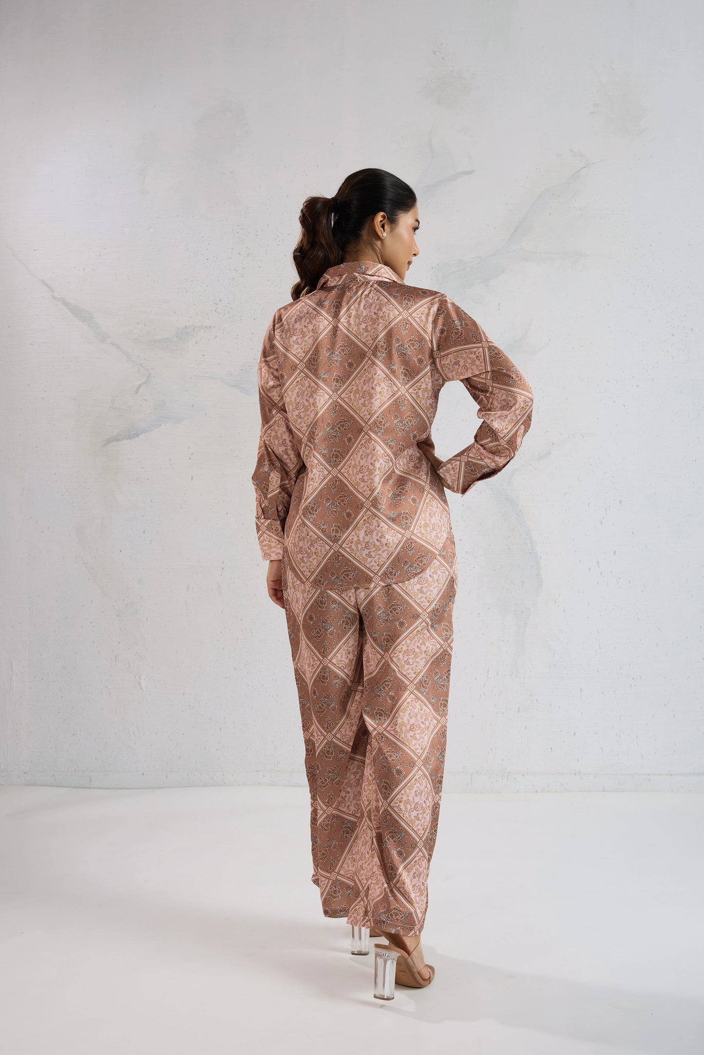 Woman wearing a patterned outfit on a white background