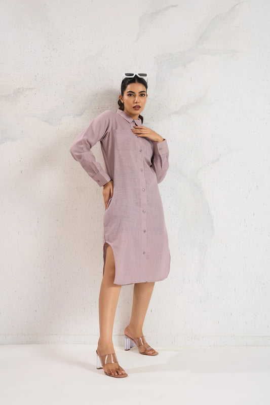 Woman wearing a pink shirt dress against a white background