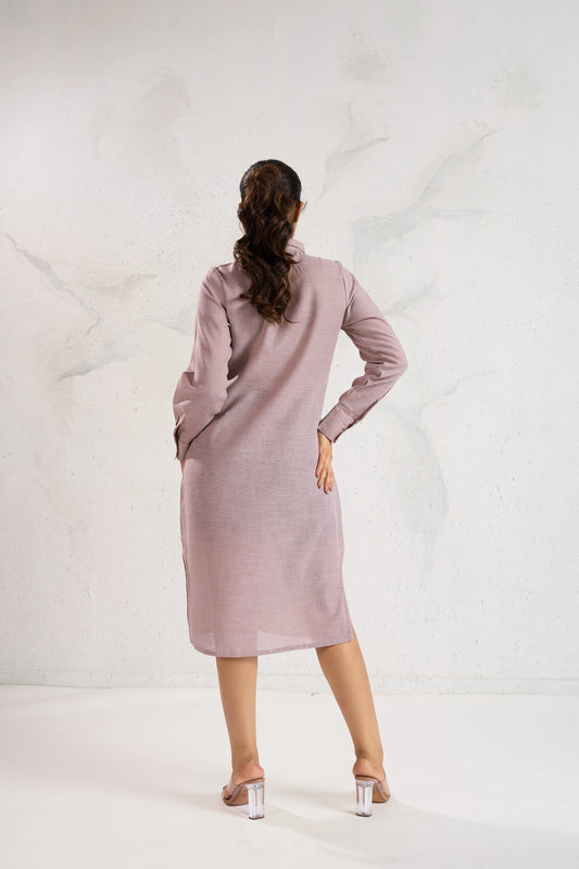 Woman wearing a light pink dress standing against a white background