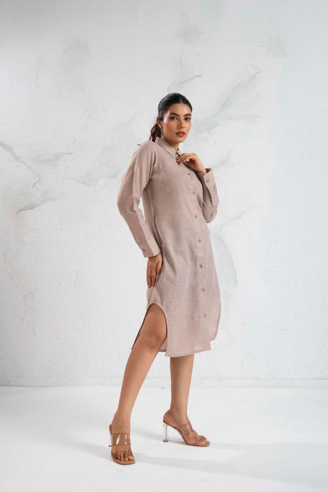 Woman wearing a beige dress against a white background
