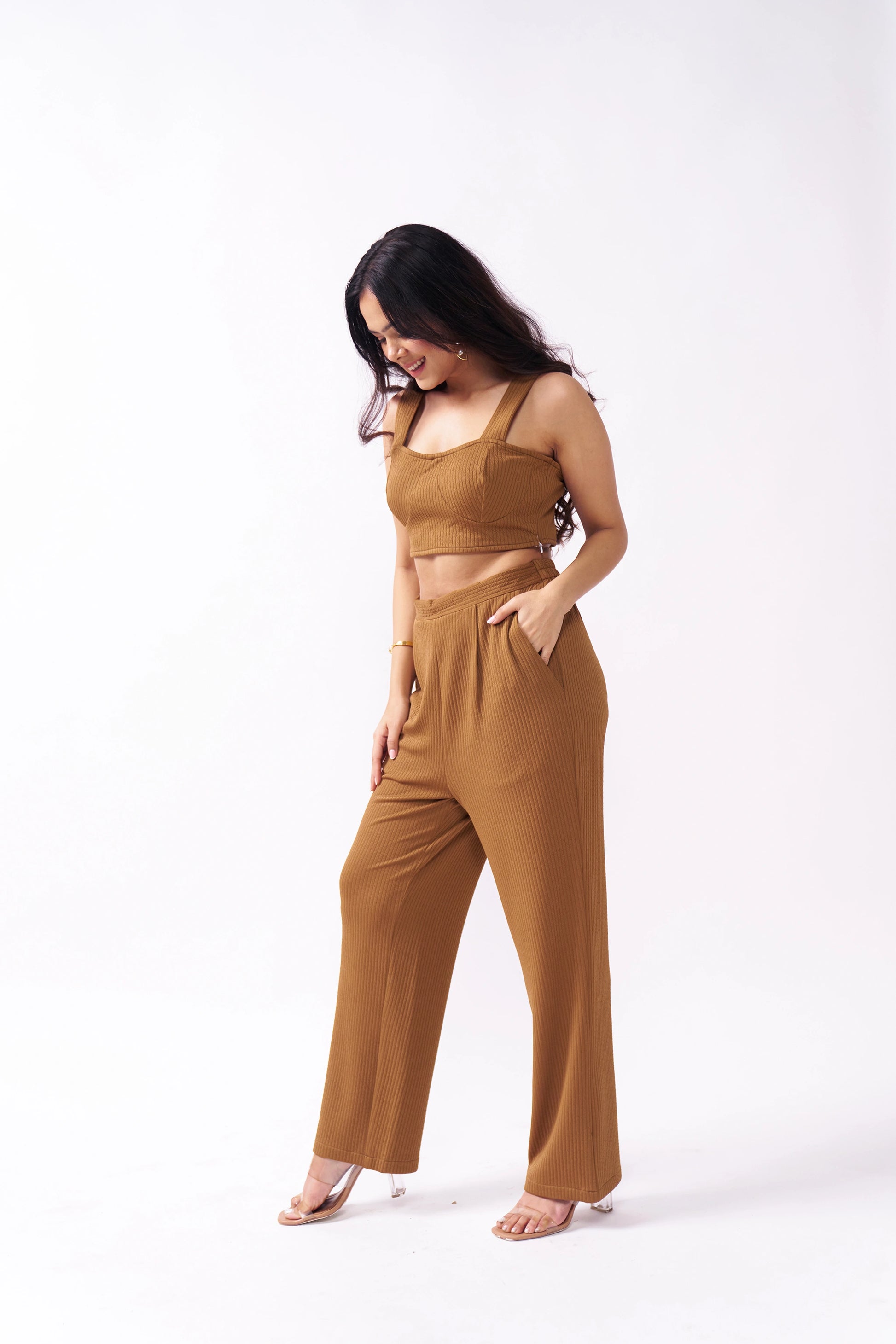 Woman wearing a brown jumpsuit on a white background