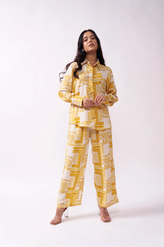 Woman wearing a yellow and white patterned outfit on a white background
