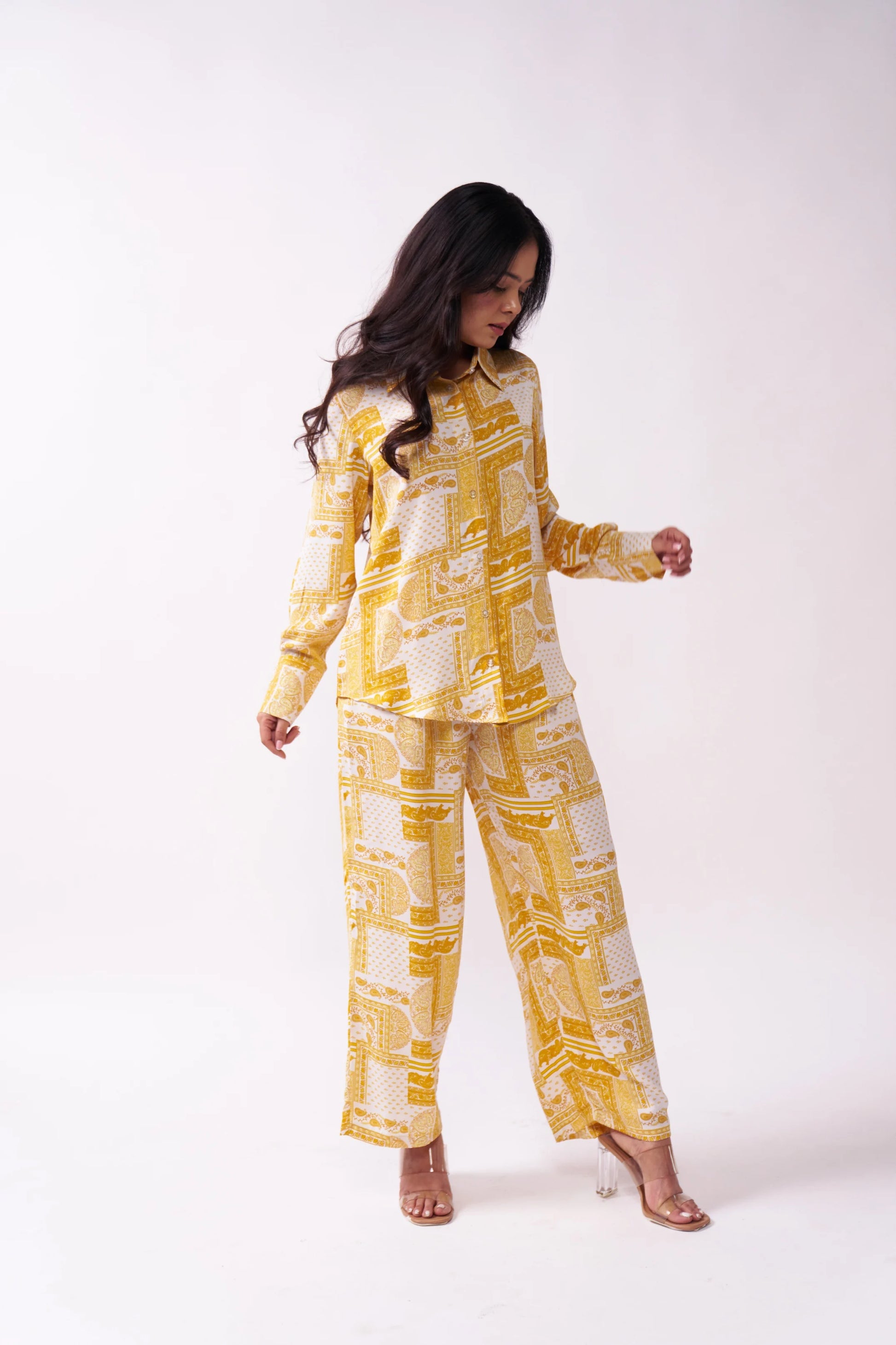Woman wearing a yellow and white patterned outfit on a white background