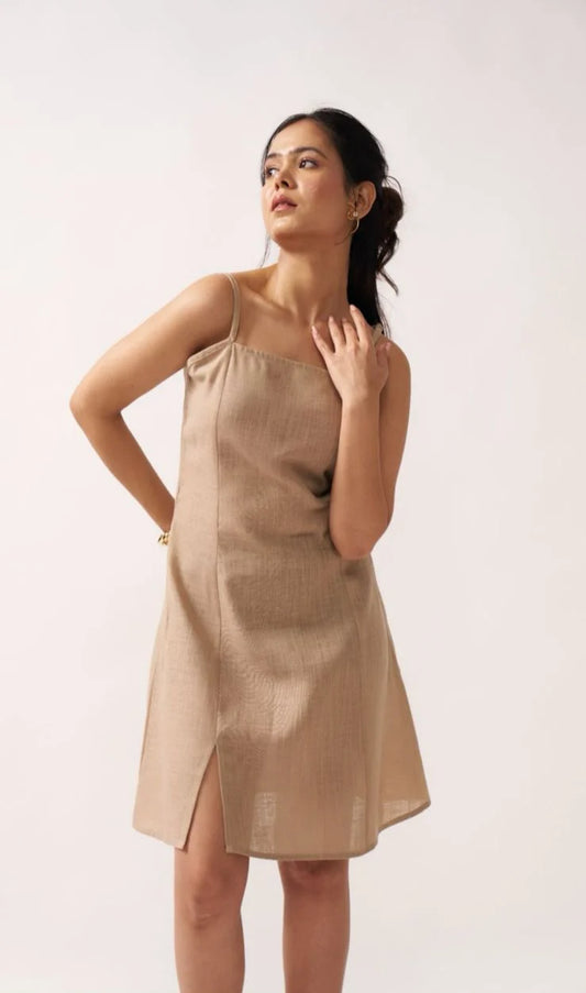 Woman wearing a beige dress against a white background