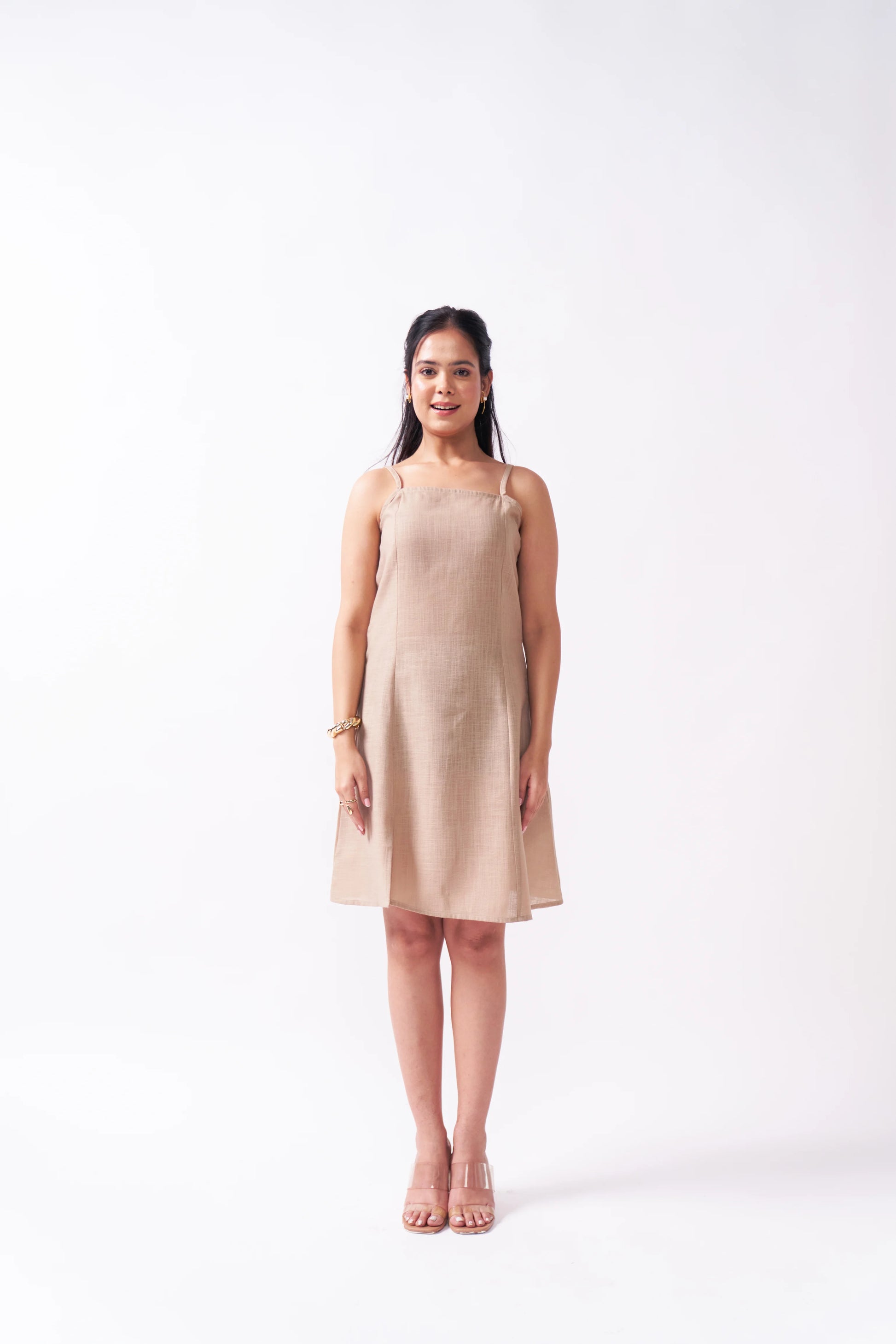Woman wearing a beige dress on a white background