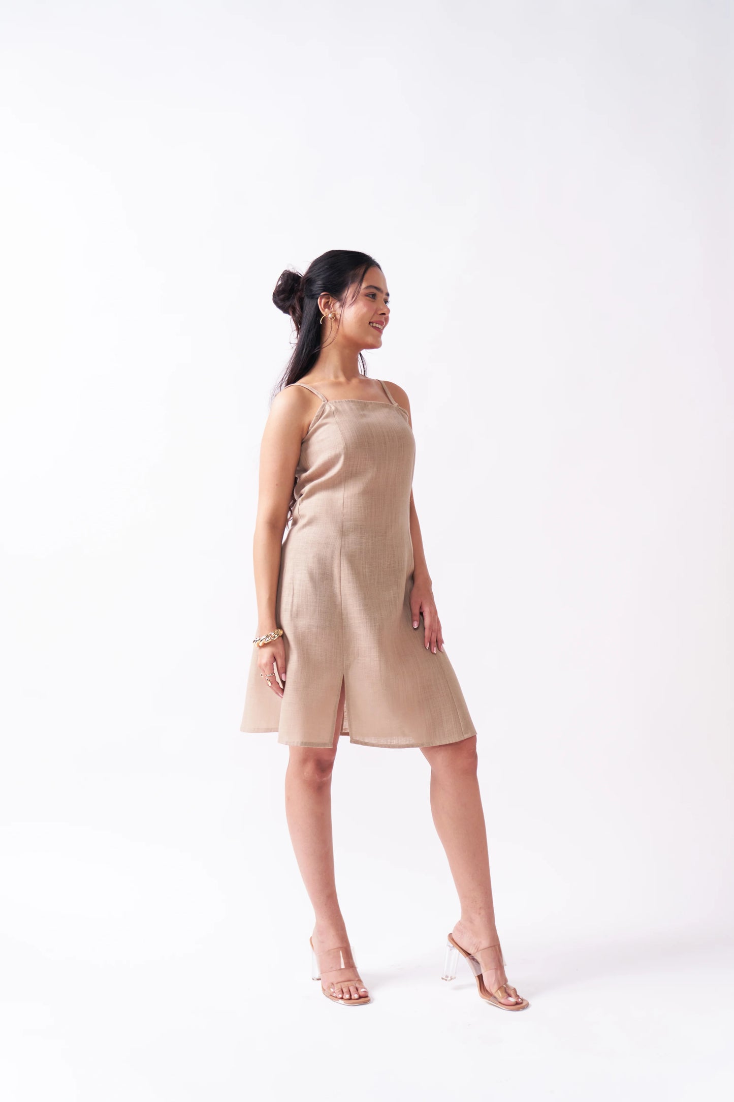 Woman wearing a beige dress on a white background