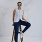 Woman sitting on a stool wearing a white sleeveless top and blue jeans against a white background