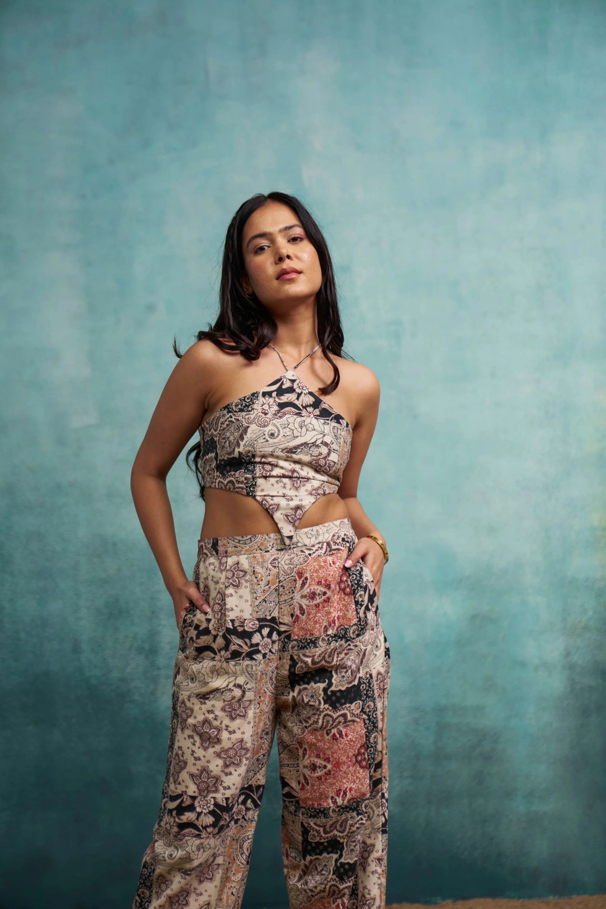 Woman wearing a patterned outfit against a textured blue background