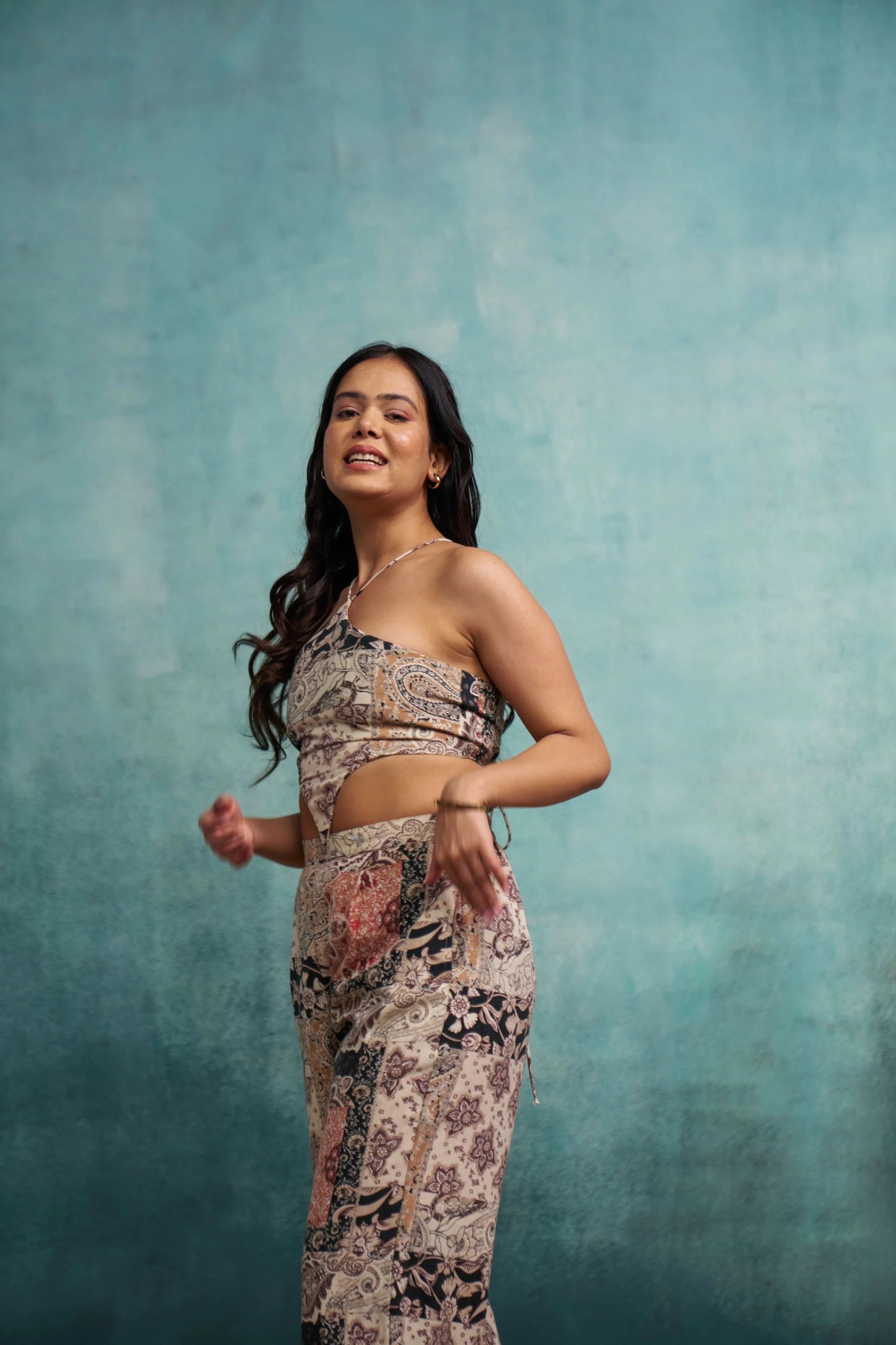 Woman wearing a patterned outfit against a textured blue background