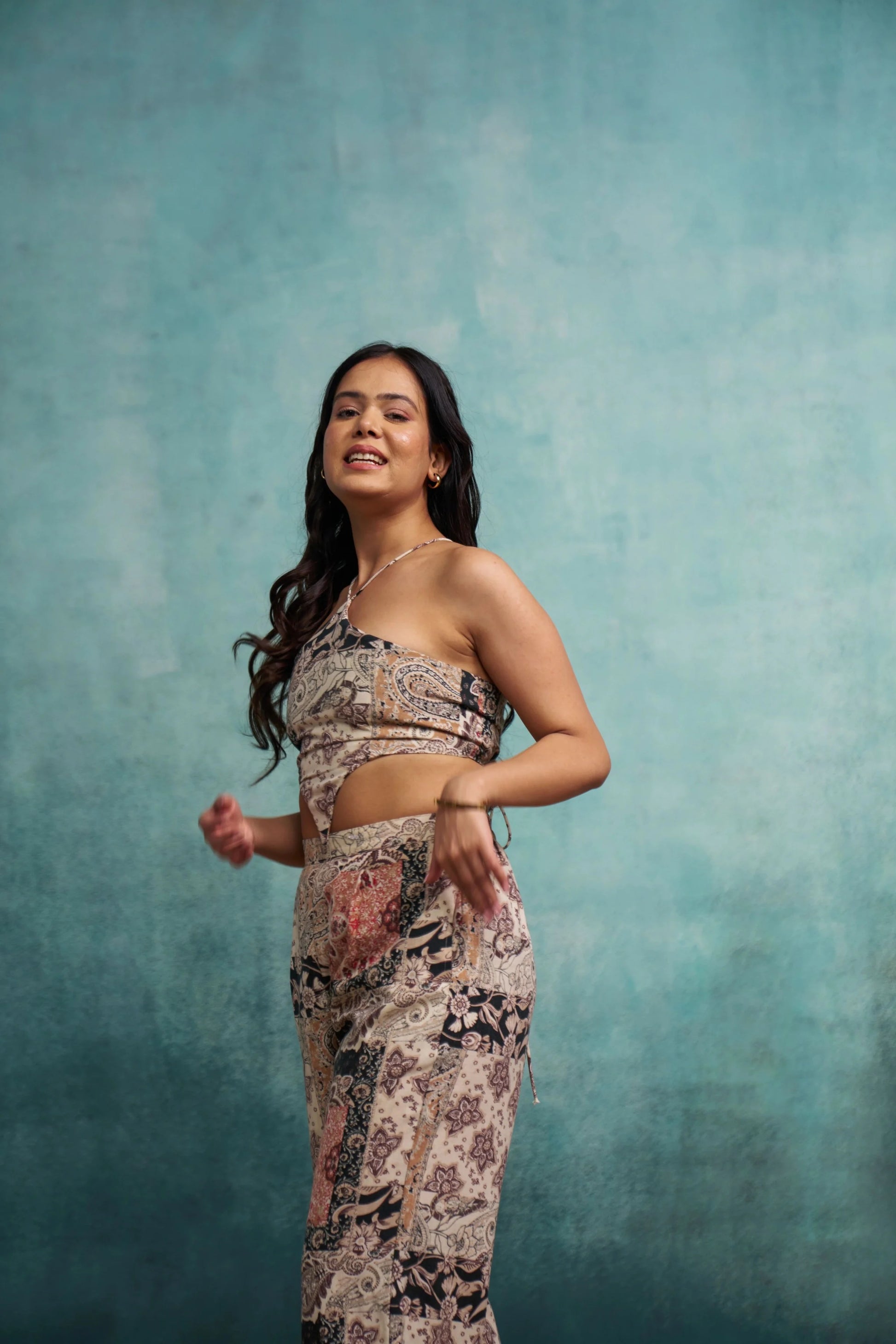 Woman wearing a patterned outfit against a textured blue background