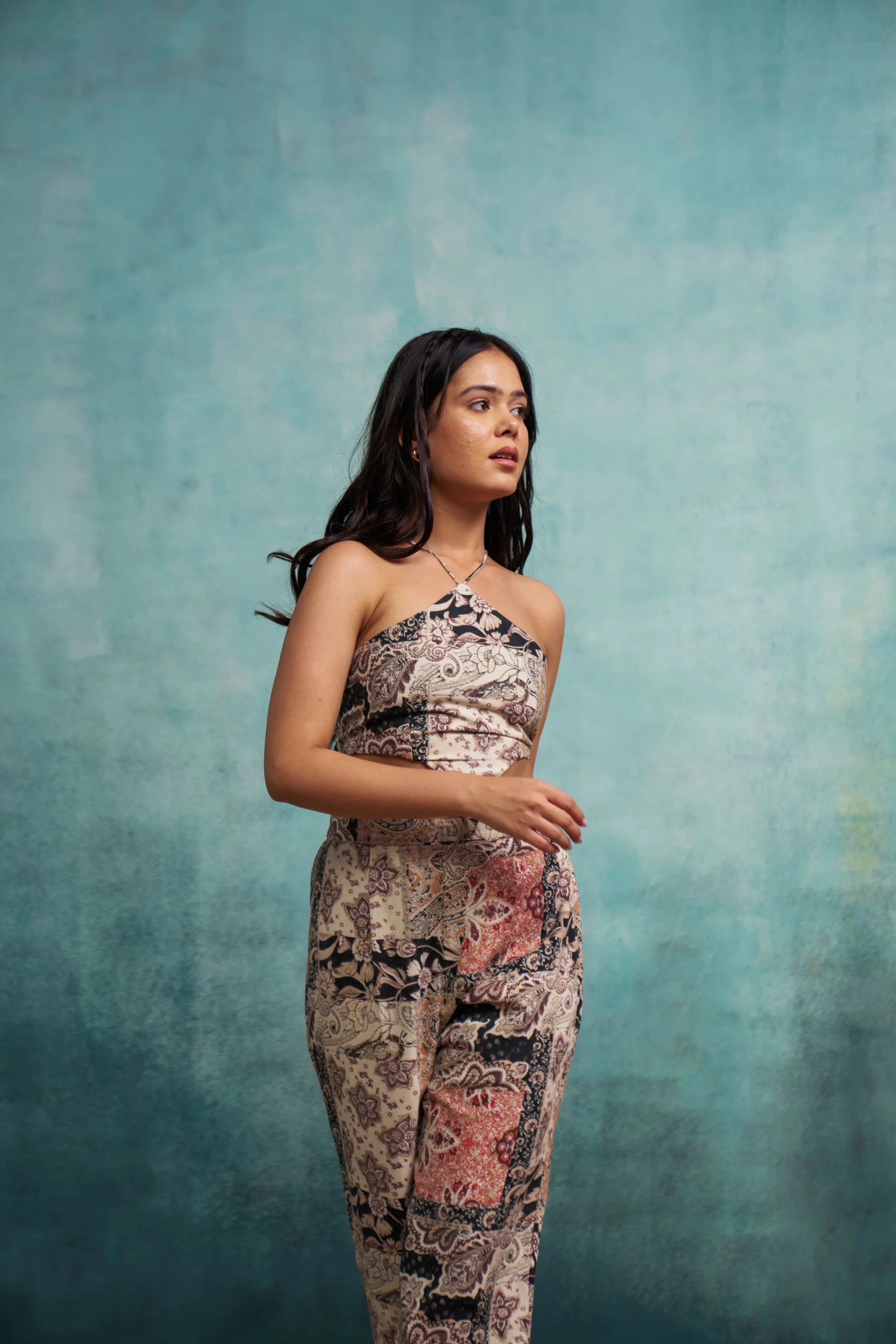 Woman wearing a patterned dress against a textured blue background